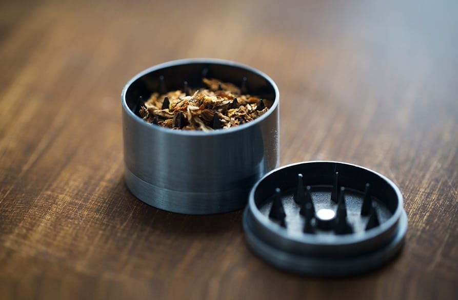 Photo d'un grinder avec du cannabis, prêt pour l'utilisation.