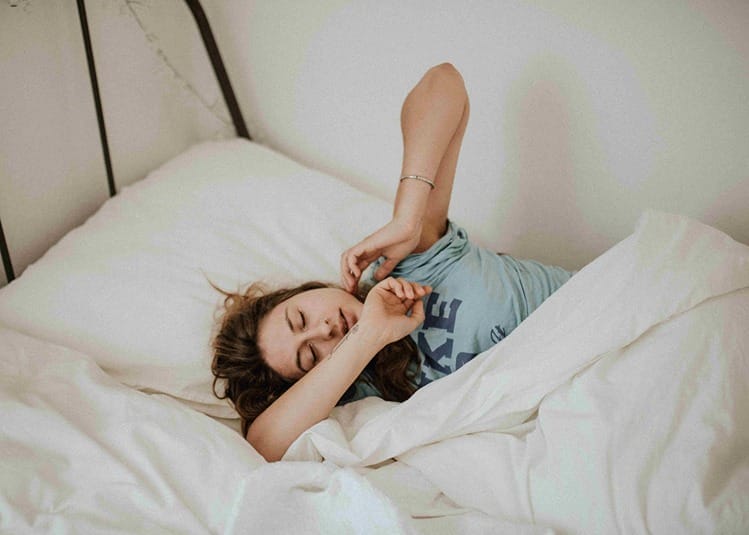 Une femme dans son lit qui somnole