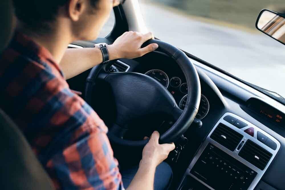 Homme ayant consommé du CBD à l'intérieur d'un véhicule tenant le volant de sa voiture